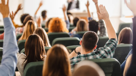 student raising hands in classroom