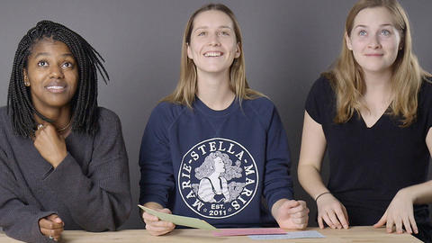 Lexi, Emily, and Kate sitting around a table making silly faces at the camera.