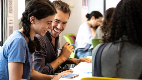 Two students talking with each other at a table