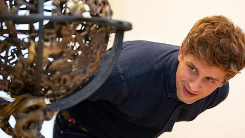 Student leans over to better study a piece of art at the Harvard Art Museums