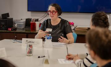 Sarah Emory gestures with her hands while explaining a concept during a seminar.