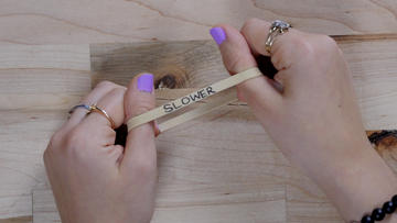Two hands stretching a rubber band labeled "slower."