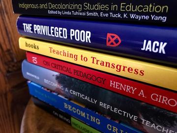 A stack of books on topics of critical pedagogy and equity and inclusion.
