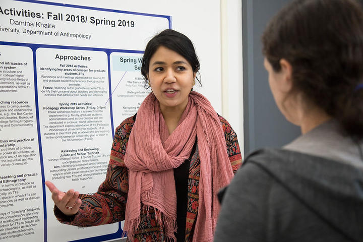 A pedagogy fellow presents a poster during the program's capstone event.