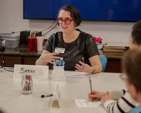 Sarah Emory gestures with her hands while explaining a concept during a seminar.