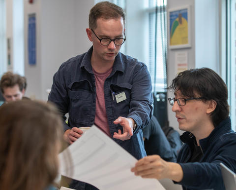 Jonah Johnson gestures toward a paper that a student is holding during a Bok Seminar.